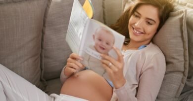 A Complete Pregnancy Health Guide for Expecting Mothers Woman,,Happiness,And,Pregnancy,Book,On,Couch,For,Research,,Planning